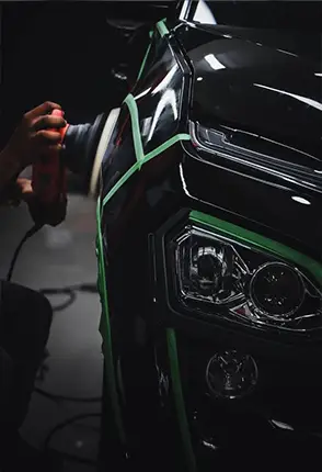 Detailer using a professional polishing machine on vehicle paint