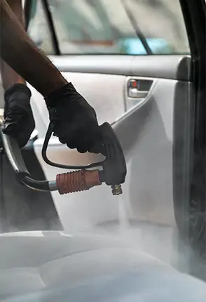Detailer operating professional cleaning equipment