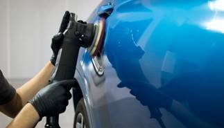 Professional machine polishing on a blue vehicle